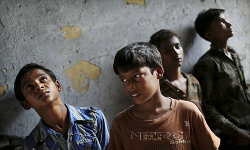 Indian bonded child laborers wait to be taken away after being rescued during a raid by workers from the Save the Childhood Movement, at a garment factory in New Delhi, India on June 12, 2012. Photo: IC