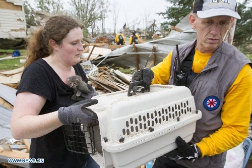People rescue a cat on the wreckage in Shawnee, Oklahoma, the United States, May 20, 2013. Two men were confirmed dead after tornadoes hit the U.S. state of Oklahoma, officials said Monday. (Xinhua/Marcus DiPaola) 
