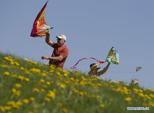 People fly kites during the 24th Annual Four Winds Kite Festival at the Kortright Centre for Conservation in Toronto, Canada, May 4, 2013. (Xinhua/Zou Zheng)