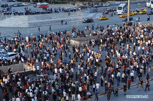 Protestors stand silently in front of Ataturk culture centre near the Taksim Square in Istanbul, Turkey, on June 18, 2013. Hundreds of people stood silently from morning to evening on Tuesday here to protest against the government. Nationwide protests began when an environmentalists' rally aiming to preserve Gezi Park adjacent to Taksim Square in Istanbul met fierce police crackdown, which triggered a wave of fiery opposition against the government's policies. (Xinhua/Lu Zhe) 