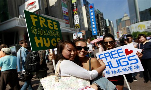Nearly 40 expats on the Nanjing Road Pedestrian Street offer free hugs to passersby Sunday to solicit blood donations. Photo: Yang Hui/GT