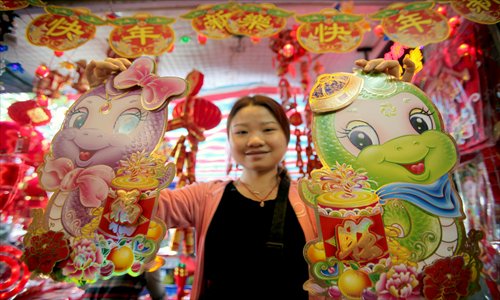 A resident in Haikou, Hainan Province displays her snake decorations. Photo: CFP