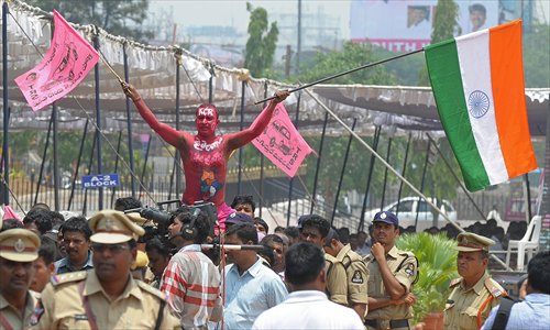 A supporter gestures while clad in body paint bearing the name of Rao during the celebrations in Secunderabad on Monday. Telangana has been carved out of an impoverished northern area of Andhra Pradesh state. Hyderabad, an IT hub home to giants Google and Microsoft, will serve as the capital of both states for the next decade.