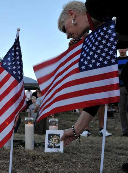 A woman places a card for victims near the movie theater where the shooting rampage happened in Aurora, Colorado, July 20, 2012. Photo: Xinhua