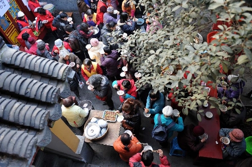  Citizens eat porridge at the Xuanzang Temple in Nanjing, capital of east China's Jiangsu Province, Jan. 19, 2013, to celebrate the traditional Laba Festival. Laba literally means the eighth day of the 12th lunar month. The Laba Festival is regarded as a prelude to the Spring Festival, or Chinese Lunar New Year, the most important occasion of family reunion, which falls on Feb. 10 this year. Eating porridge is an old tradition on the Laba Festival in China. Many temples also have the tradition of offering porridge to the public to commemorate Buddha and deliver his blessings to both believers and non-believers. (Xinhua/Sun Can) 