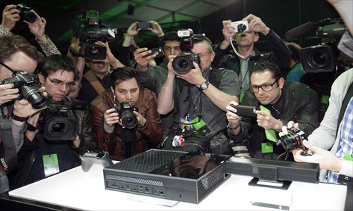 Members of the media take photos and shoot video at the unveiling of Microsoft Corp's first new Xbox in almost eight years in Redmond, Washington, US, on Tuesday. The player, called Xbox One, is set to go on sale later this year and will use voice commands and motion sensing to recognize users and let them switch seamlessly between games, live TV and Skype video calling. Photo: CFP