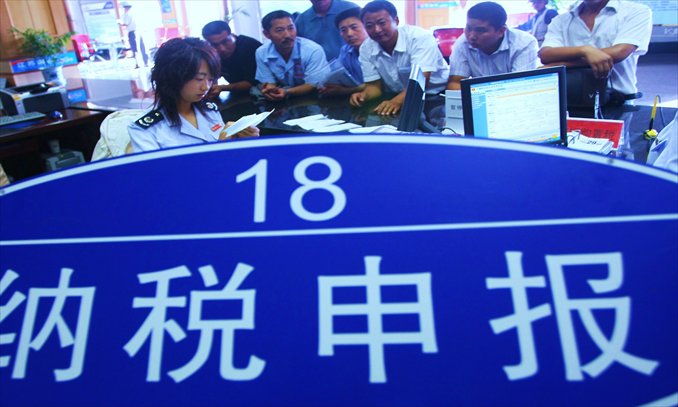 An employee handles tax levy details at a window in the State Tax Bureau of Haining county, Jiangsu Province. Photo: CFP