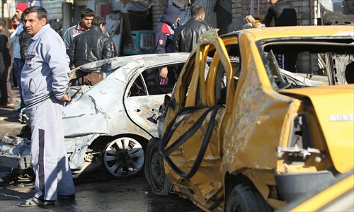 Residents look at damaged cars after a car bomb killed at least three people on Thursday, near a police station near Baghdad. The latest violence comes with Iraq mired in a series of crises that have raised tensions as anti-government protesters have blocked off a key trade route in more than two weeks of ongoing rallies. Photo: AFP  
