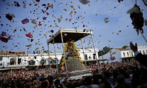 El Rocio's Virgin is carried through the streets of Almonte, during the annual El Rocio pilgrimage in the south of Spain on Monday. The pilgrimage to Almonte, home to the Virgin del Rocio, is the largest in Spain. Devotees make their way on horseback and carriages across the Andalusian countryside.  Photo: AFP