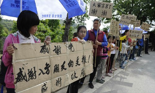 Students hold banners to express their gratitude to quake-relief workers along a road in Miaoxi village, Lushan county, Sichuan Province on April 24. Photo: Li Hao/GT