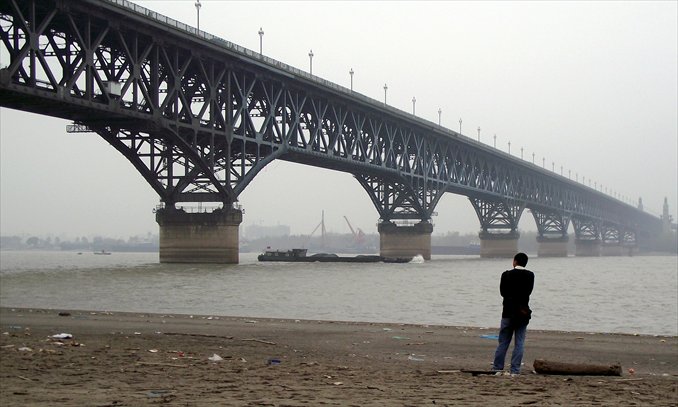 A man watches the Nanjing Yangtze River Bridge from a bank in Nanjing, Jiangsu Province. Photo: IC