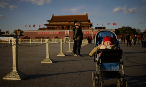 A baby sits in a pram on Tiananmen Square in Beijing on Sunday. On Friday the Communist Party of China announced an easing of the country's controversial family planning policy as part of a raft of sweeping pledges including the abolition of its re-education through labor system and loosening controls on the economy. Photo: AFP