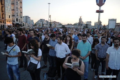 Protestors stand silently in front of Ataturk culture centre near the Taksim Square in Istanbul, Turkey, on June 18, 2013. Hundreds of people stood silently from morning to evening on Tuesday here to protest against the government. Nationwide protests began when an environmentalists' rally aiming to preserve Gezi Park adjacent to Taksim Square in Istanbul met fierce police crackdown, which triggered a wave of fiery opposition against the government's policies. (Xinhua/Lu Zhe) 