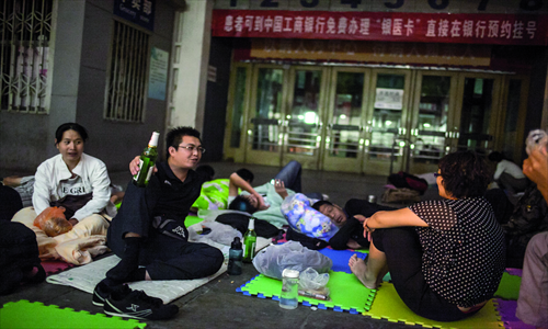People make friends with their neighbors in line while they wait.
Photos: Li Hao/GT 


