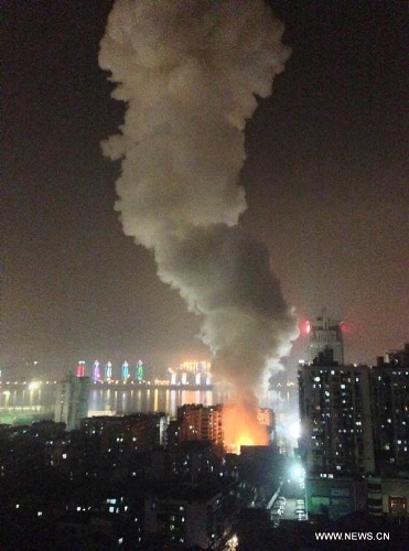  Fire and smoke are seen at a residential building in Wuhan, capital of central China's Hubei Province, March 19, 2013. An explosion ripped through a residential building in Wuhan Tuesday night. Casualties of the blast are still unknown. (Xinhua/Liu Wei)