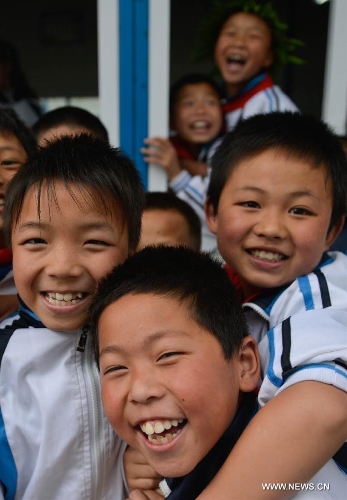 Students of the central primary school of Shangli Town have fun during class break in Shangli, Lushan County, southwest China's Sichuan Province, May 16, 2013. The schoolhouses of the Shangli Town Center School were destroyed in the 7.0-magnitude earthquake taken place in Lushan on April 20, leaving more than 1, 200 students to have classes in newly built prefab houses. (Xinhua/Liu Xiao)  