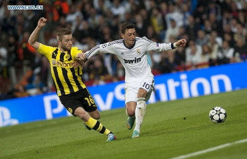 Real Madrid's Mesut Ozil (R) vies with Borussian Dortmund's Jakub Blaszczykowski during the UEFA Champions League semi-final second leg football match in Madrid, capital of Spain, April 30, 2013. Borussia Dortmund qualified for the Champions League final, beating Real Madrid 4-3 on aggregate despite a 2-0 loss Tuesday. (Xinhua/Xie Haining) 