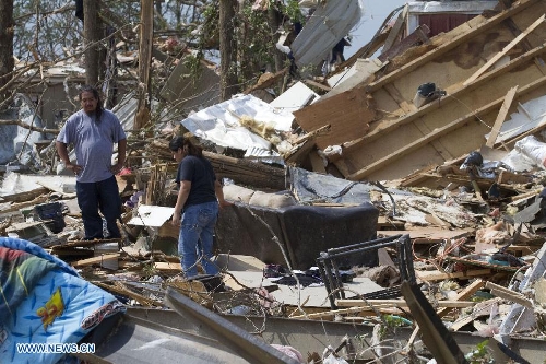 A man and a woman look through the wreckage in Shawnee, Oklahoma, the United States, May 20, 2013. Two men were confirmed dead after tornadoes hit the U.S. state of Oklahoma, officials said Monday. (Xinhua/Marcus DiPaola) 