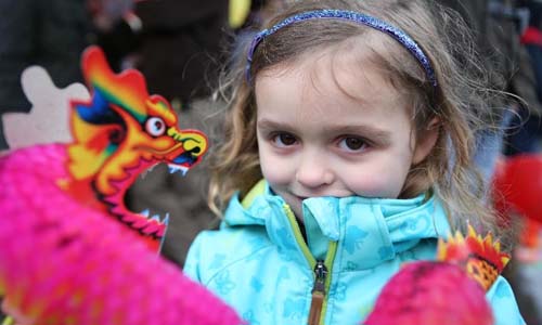A girl poses with a toy Chinese dragon during a celebration marking the Chinese Lunar New Year in London, Britain, on Feb. 10, 2013. Photo: Xinhua
