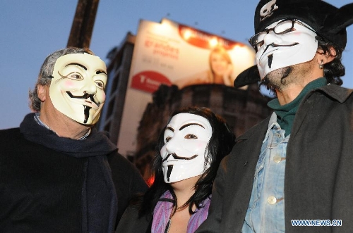 Protestors wearing masks take part in the protest in front of the Internatioanl Monetary Fund (IMF) Office in Lisbon, Portugal, on Jan, 30, 2013. Hundreds of Portuguese gathered in front of the Internatioanl Monetary Fund (IMF) Office in capital Lisbon, protesting against IMF's demand of more spending cuts by the Portuguese government and its drastic austerity policy. (Xinhua/Zhang Liyun)