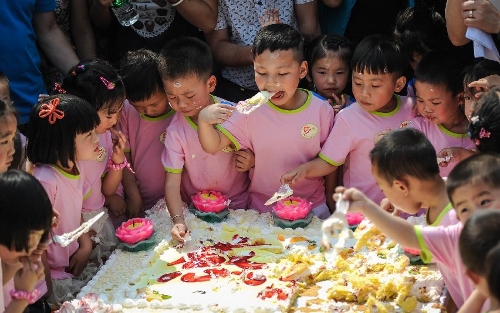 Children eat cake at a birthday party at the Luohan Temple in Shifang City, southwest China's Sichuan Province, May 12, 2013. The children were born at the Luohan Temple five years ago after the devastating earthquake jolted Wenchuan County of Sichuan on May 12, 2008. The temple then was used as a temporary obstetrics hospital from May 13 to Aug. 7 in 2008 to deliver newborn babies. A total of 108 babies were born at the temple until the local maternal and child health care hospital reopened. (Xinhua/Jiang Hongjing) 