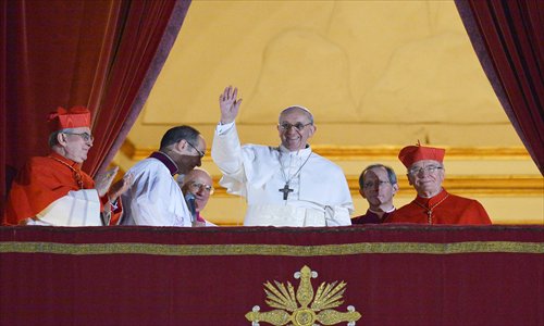 Argentina's Jorge Mario Bergoglio, elected Pope Francis (center), waves from the window of St Peter's Basilica's balcony after being elected the 266th pope of the Roman Catholic Church on Thursday at the Vatican. Pope Francis became the first Jesuit and non-European pope in 1,300 years to lead the world's 1.2 billion Catholics. Photo: AFP 