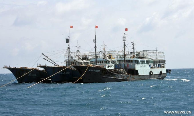 Fishing boats lie at anchor in the waters at Meiji Reef of South China Sea on July 22, 2012. There are nearly a score of fishermen working regularly at a fish farm at Meiji Reef, where high-value fishes are fed for years. Photo: Xinhua