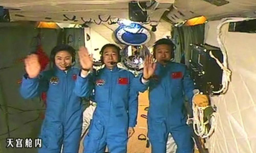 This screen shot taken on June 26, 2012 shows the Chinese astronauts who are conducting scientific tests in Tiangong-1 space lab module waving hands in Tiangong-1. Chinese President Hu Jintao came to the Beijing Aerospace Control Center on Tuesday and talked with the astronauts. Photo: Xinhua