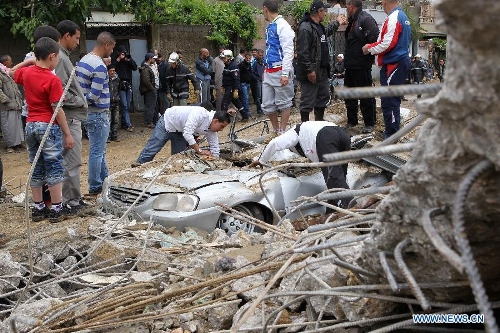 Local residents try to make the clearance of a car stuck in mud in Beni Messous suburb, in upper Algiers, Algeria, on May 22, 2013. Heavy rain poured since Tuesday in several provinces in northern part of the country, claiming the life of one citizen, injuring three others, and causing extensive damages. (Xinhua/Mohamed Kadri) 