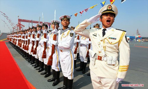 Military officers salute onboard China's aircraft carrier 