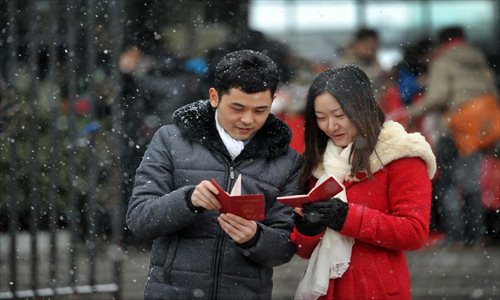 A couple look at their marriage certificates after registering in the marriage registration office in Furong district of Changsha, capital of Central China's Hunan Province, January 4, 2013. Quite a number of couples flocked to tie the knot on January 4, 2013, or 2013/1/4, which sounds like 