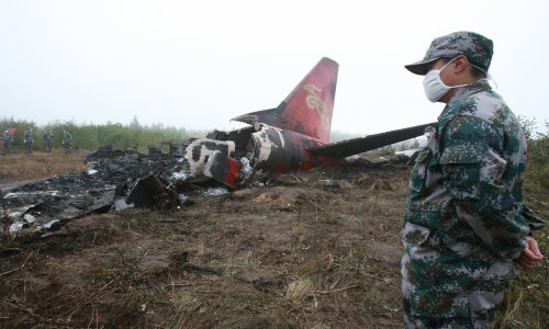 Soldiers guard the remains of a crashed plane on August 25, 2010. The plane, which belonged to Henan Airlines, had crashed while landing at an airport in Yichun, Heilongjiang Province the previous night. Photo: CFP