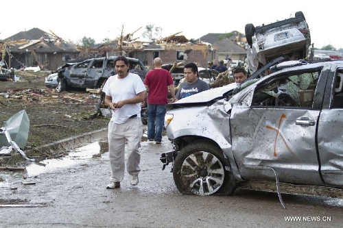 People pick through the wreckage after a tornado in Moore, Oklahoma, the United States, on May 20, 2013. Twenty-four people were killed and 237 others injured when a massive tornado blasted the southern suburbs of Oklahoma City, the capital of the U.S. state of Oklahoma, on Monday, state officials said Tuesday. (Xinhua/Marcus DiPaola)