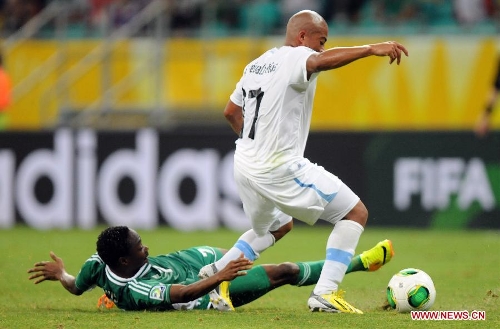 Nigeria's Ahmed Musa (Bottom) vies for the ball with Egidio Arevalo of Uruguay during the FIFA's Confederations Cup Brazil 2013 match in Salvador, Brazil, on June 20, 2013. Uruguay won 2-1. (Xinhua/Nicolas Celaya)  