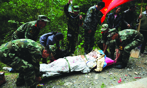 Soldiers carry an injured person in Lingguan, Baoxing county on Sunday. Photo: Li Hao/GT