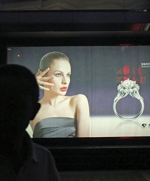 A person passes a billboard for a Chinese jeweler. China imported 4.12 million carats worth of diamonds in the first quarter, up 26.9 percent year-on-year, according to official figures released Wednesday, mainly in response to growing local demand for diamond wedding rings. Photo: CFP
