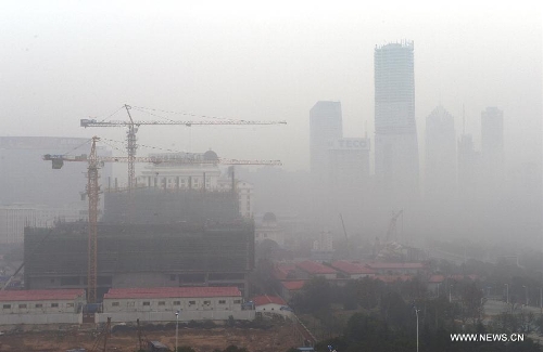 Fog-shrouded buildings are seen in the Honggutan New District of Nanchang City, capital of east China's Jiangxi Province, Jan. 12, 2013. A fog hit many parts of Jiangxi on Saturday. (Xinhua/Song Zhenping) 