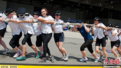 Policewomen pull on the rope connected to the Airbus A320 during the fourth annual Plane Pull' May 20, 2013 at JFK airport in New York. Teams of police officers from London's Metropolitan Police Service, city police officers, state police troopers and employees of British Airways PLC and JetBlue Airways Corp. race to move the Airbus A320 jet 100 feet in the fastest time, during the competition to benefit the charity Joining Against Cancer in Kids. (Photo Source: chinanews.com)
