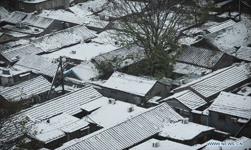 House roofs are covered by snow in Beijing, capital of China, on November  4, 2012. The capital city had witnessed snowfall and sleet since Saturday night as cold current swept north China and dropped temperature. Photo: Xinhua
