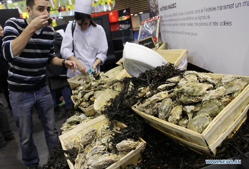 A man tastes an oyster at the International Hospitality and Food Service Fair (SIRHA) in Lyon, France, on Jan. 30, 2013. The five-day fair was closed on Wednesday. The biyearly SIRHA was founded in 1984 and is considered one of the most influential food expos in Europe. (Xinhua/Gao Jing)