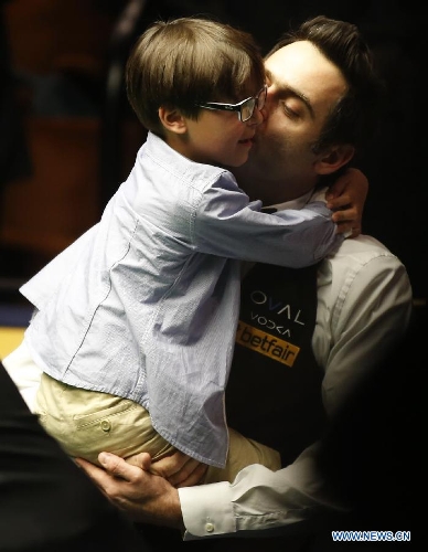 Ronnie O'Sullivan (R) of England celebrates with his son Ronnie Junior during the awarding ceremony for 2013 World Snooker Championship at the Crucible Theatre in Sheffield, Britain, May 6, 2013. Ronnie O'Sullivan sealed his fifth world title by defeating Barry Hawkins of England with 18-12 in the final. (Xinhua/Wang Lili) 