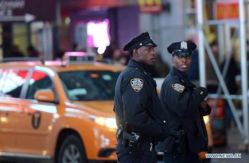 Two policemen patrol at the Times Square in New York, the United States, Jan. 16, 2013. New York State Governor Andrew Cuomo on Tuesday signed the NY Safe Act following the Assembly has voted overwhelmingly in favor of the bill, which was seen as the toughest gun control law in the nation and the first since the Newtown school shooting. (Xinhua/Wang Lei)