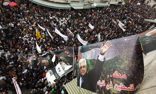 Palestinian supporters of the President Mahmud Abbas hold his pictures during a support rally in the West Bank town of Ramallah on Monday, ahead of Abbas meeting with the US President Barack Obama in Washington. Photo: CFP