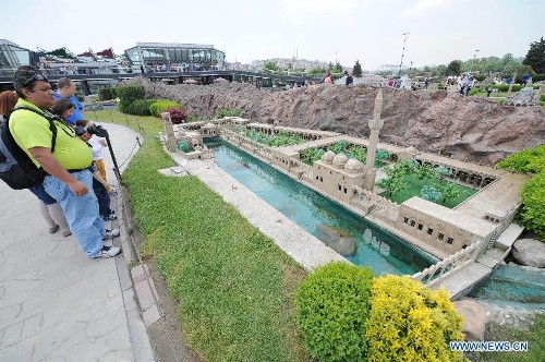 Visitors look at the miniature of Halil-ur Rahman Mosque in the Miniature park in Istanbul, Turkey, on May 11, 2013. The Miniaturk park is the first miniature park in Istanbul and has welcomed 6.5 million visitors over the past 10 years. (Xinhua/Lu Zhe) 