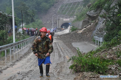Communication emergency workers walk into rainstorm-hit Beichuan Qiang Autonomous County, southwest China's Sichuan Province, July 9, 2013. Downpours have submerged the quake-razed old town ruins of Beichuan, which was hit by an 8.0-magnitude earthquake in May 2008. (Xinhua)