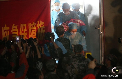 Medical workers carry a newborn child named Zhang An out of a temporary delivery room in the quake-hit Lushan County, southwest China's Sichuan Province, April 22, 2013. Liu Li, a villager of Luyang Township of Lushan County, gave birth to the baby girl Zhang An on Monday night. A 7.0-magnitude earthquake jolted Lushan County on April 20, leaving at least 192 people dead and 23 missing. More than 11,000 people were injured. (Xinhua/Jin Liwang) 