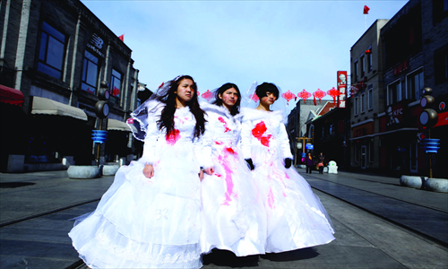The girls raise awareness about domestic violence through wearing bloodied wedding dresses. Photo: Guo Yingguang/GT