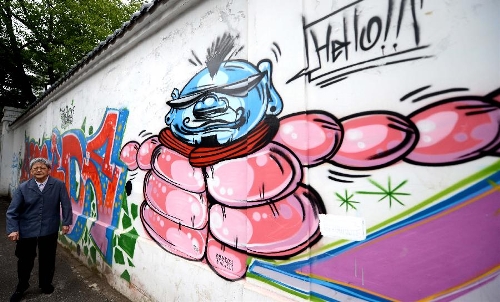 Photo taken on May 19, 2013 shows a wall decorated with graffiti in Nanchang, capital of east China's Jiangxi Province. Two graduates from the Academy of Arts and Design in Hunan University of Science and Technology designed those graffiti to express their opinions of fashion. (Xinhua/Zhou Ke)