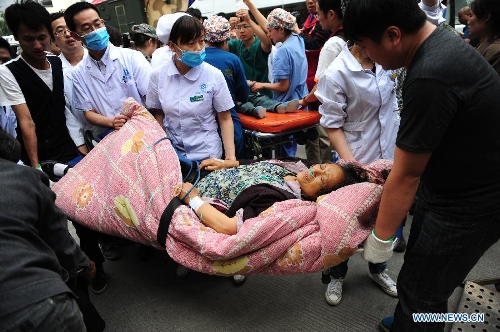 People carries an injured woman in the People's Hospital in the quake-hit Lushan County, southwest China's Sichuan Province, April 21, 2013. Military and civilian rescue teams are struggling to reach every household in Lushan and neighboring counties of southwest China's Sichuan Province, badly hit by Saturday's strong earthquake. (Xinhua/Li Hualiang) 