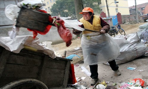 An 80-year-old woman cleans up trash on a street in Jiujiang, Jiangxi Province, in January this year. Photo: CFP